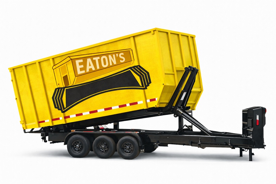 Yellow Eaton’s roll-off dumpster mounted on a black tri-axle trailer, ideal for heavy-duty construction debris hauling.