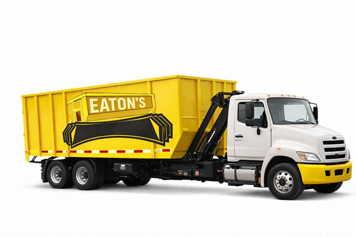 White roll-off truck carrying a yellow Eaton’s dumpster container on a black hydraulic frame, isolated on a white background.